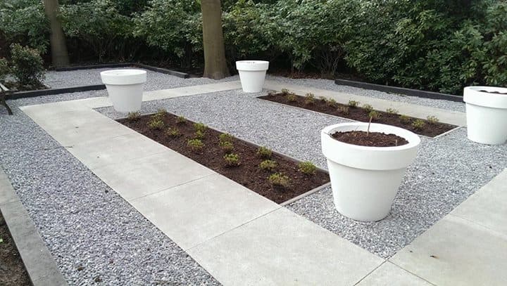 Strak grindterras met bestrating en witte plantenbakken