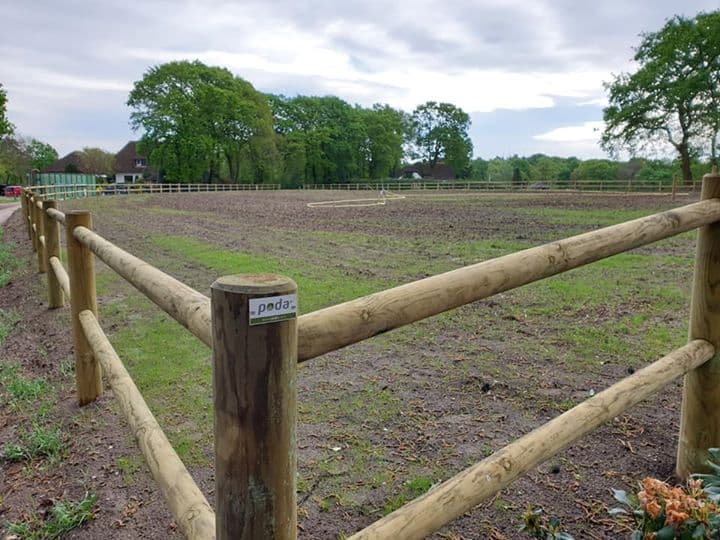 Landelijke tuin met een houten hekwerk langs een weiland