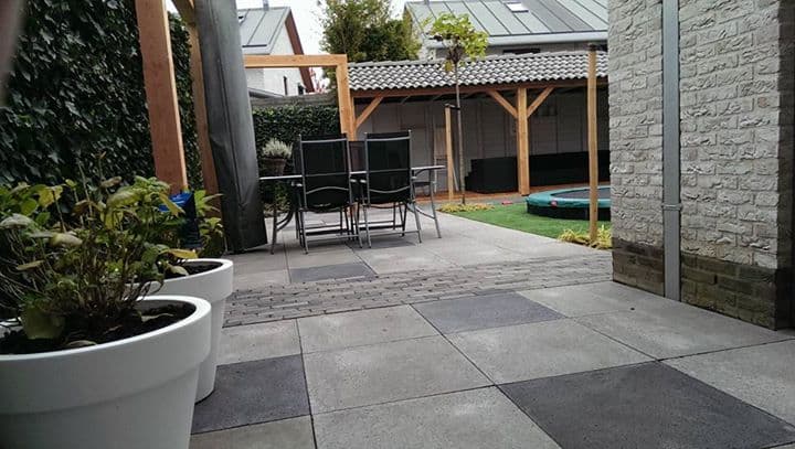 Houten veranda met een tafel en stoelen in een aangelegde tuin
